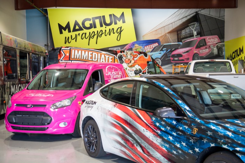 Fleet vehicles wrapped inside the Magnum shop