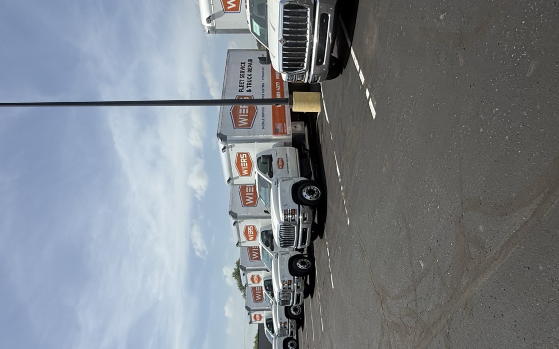 A row of matched WIERS fleet service trucks wrapped by Magnum Wrapping.