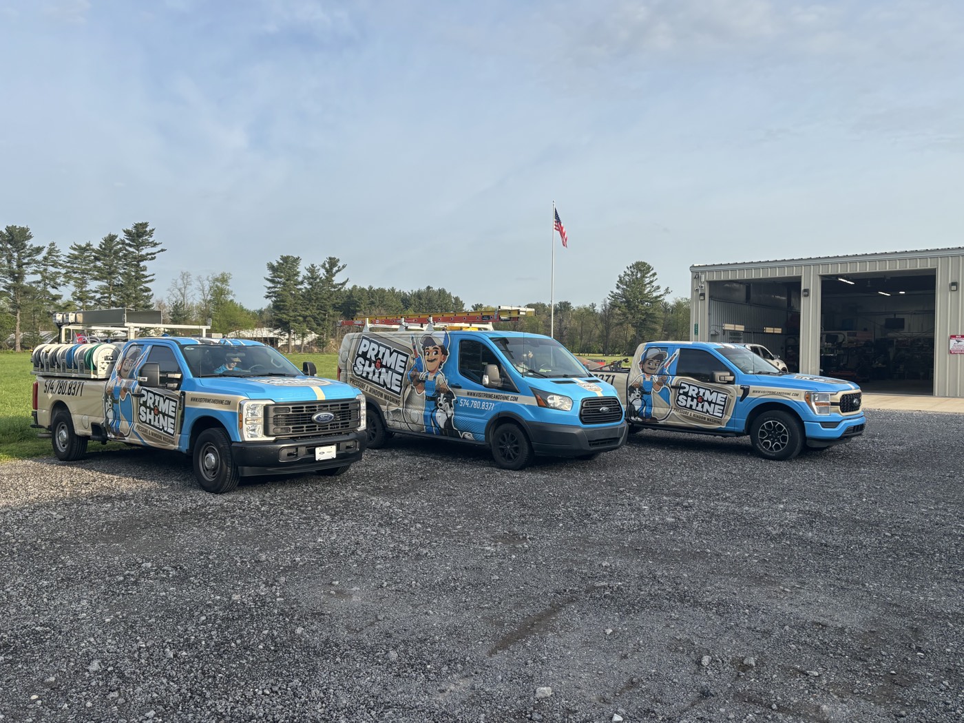 All three Prime & Shine vehicles, matching blue wraps, parked together outside the Magnum Wrapping shop.